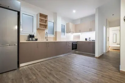 a large kitchen with wooden flooring and a large counter top at Oculus 2BD Athens Central Escape by Live&Travel in Athens