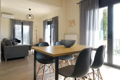 a dining room with a table and chairs at Aellō luxury apartments in Markopoulo