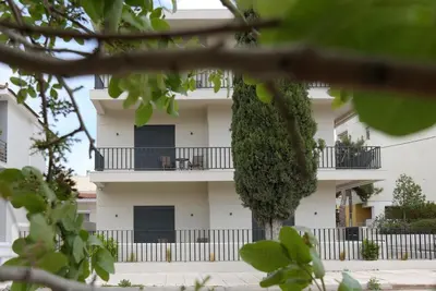 a white building with balconies on the side of it at Aellō luxury apartments in Markopoulo