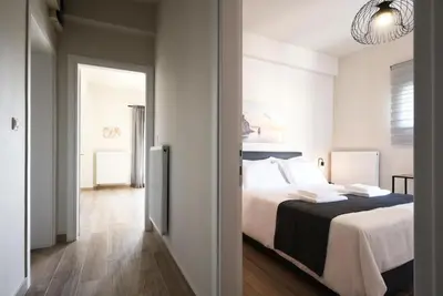 a bedroom with a large bed and a hallway at Aellō luxury apartments in Markopoulo