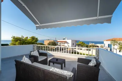a view of a balcony with chairs and a table at Nikoli House in Vaia