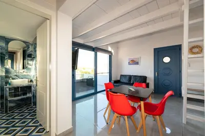 a dining room with red chairs and a table at Nikoli House in Vaia