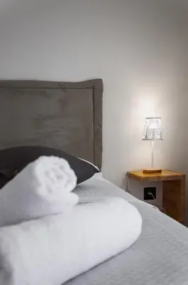 a bed with a pillow and a lamp on a table at Athens-Riviera apartment in front the sea Voula in Athens