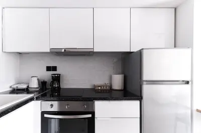 a kitchen with white cabinets and a stove top oven at Athens-Riviera apartment in front the sea Voula in Athens