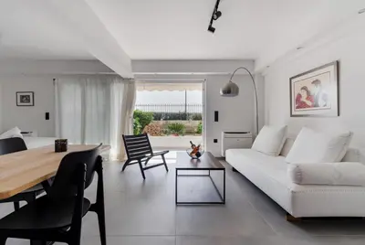 a living room with a white couch and a table at Athens-Riviera apartment in front the sea Voula in Athens