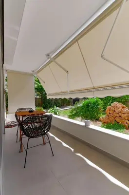 a patio with a table and chairs under a tent at Athens-Riviera apartment in front the sea Voula in Athens