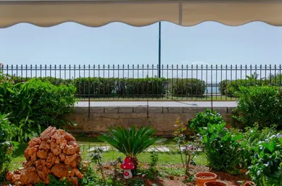 a garden with plants and an umbrella at Athens-Riviera apartment in front the sea Voula in Athens