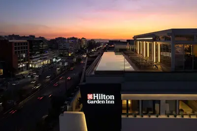 a building with a sign on the side of a city at Hilton Garden Inn Athens Syggrou Avenue in Athens