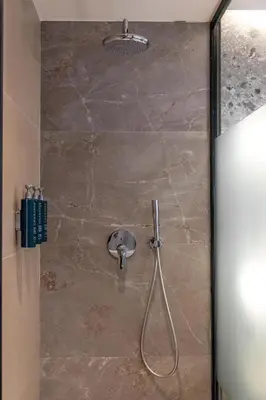 a shower with a hose attached to a stone wall at Hilton Garden Inn Athens Syggrou Avenue in Athens