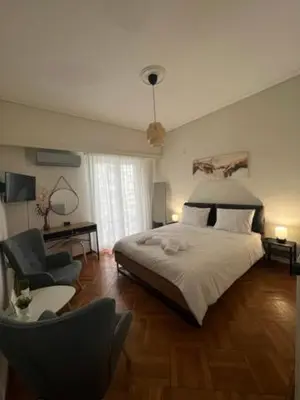 a bedroom with a large bed and a chair at Apartment in Athens in Athens