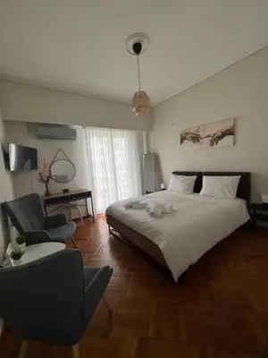 a bedroom with a large bed and a chair at Apartment in Athens in Athens