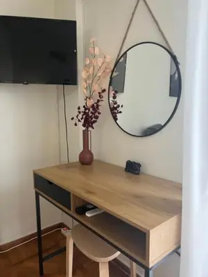 a table with a mirror and a vase with flowers at Apartment in Athens in Athens