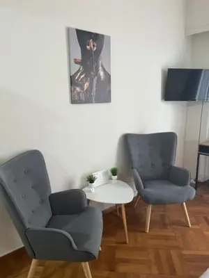 a room with two chairs and a table and a picture at Apartment in Athens in Athens