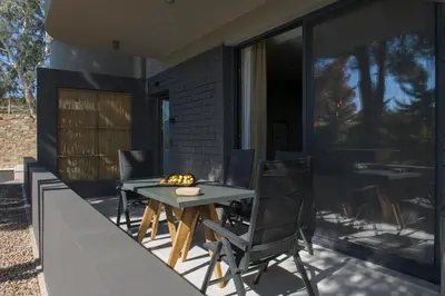 a patio with a table and chairs on a balcony at AVAL Riviera in Lagonissi