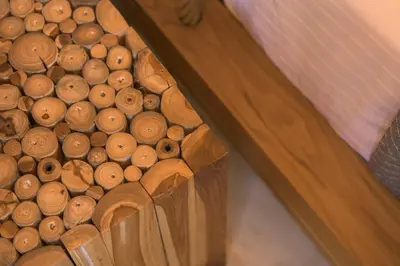 a wooden crate full of wood logs next to a bed at AVAL Riviera in Lagonissi