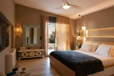 a bedroom with a large bed and a window at AVAL Riviera in Lagonissi