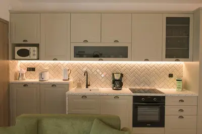 a kitchen with white cabinets and a stove top oven at AVAL Riviera in Lagonissi