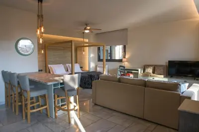 a kitchen and living room with a table and a couch at AVAL Riviera in Lagonissi