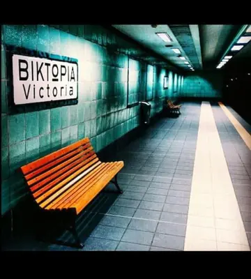 a bench in a subway station with a sign on the wall at Nice& Cozy Flat 1min from the Heart of Athens.WiFi in Athens