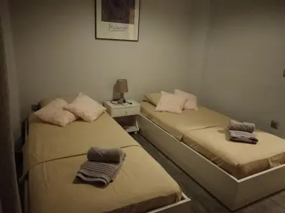 two twin beds in a room with a night stand at Nice& Cozy Flat 1min from the Heart of Athens.WiFi in Athens
