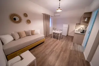 a small living room with a couch and a kitchen at Andromeda apartments in Spáta