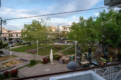 a view of a park with tables and umbrellas at Andromeda apartments in Spáta