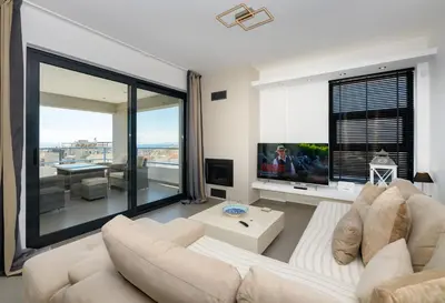 a living room with a white couch and a large window at Stylish 2BR flat with stunning views & prv parking in Athens