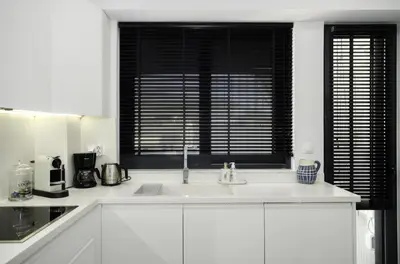 a white kitchen with a sink and a window at Stylish 2BR flat with stunning views & prv parking in Athens
