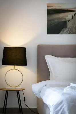 a bedroom with a bed and a table with a lamp at Stylish 2BR flat with stunning views & prv parking in Athens