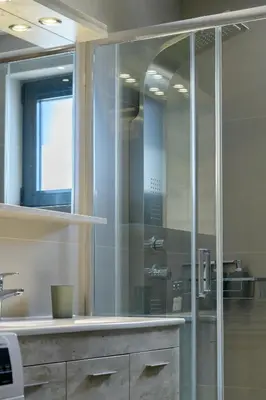 a glass shower in a bathroom with a sink at Stylish 2BR flat with stunning views & prv parking in Athens