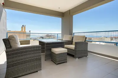 a balcony with wicker chairs and a table on a roof at Stylish 2BR flat with stunning views & prv parking in Athens
