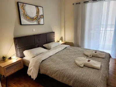 a bedroom with a large bed with two pillows on it at Acropolis Suite greendom in Athens