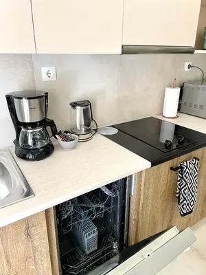 a kitchen with an open dishwasher in a counter at Acropolis Suite greendom in Athens