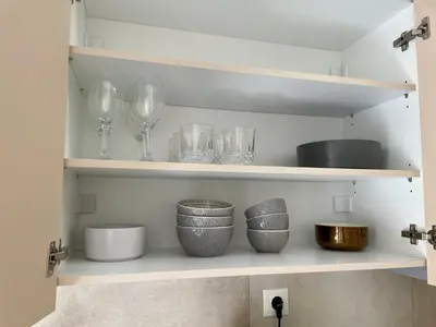a shelf with wine glasses and bowls on it at Acropolis Suite greendom in Athens