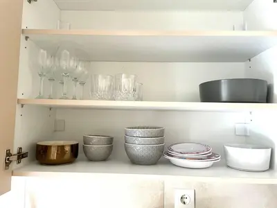 a kitchen shelf with bowls and glasses on it at Acropolis Suite greendom in Athens