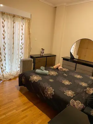 a bedroom with a bed with a black blanket with flowers at Kalamaki Apartments in Athens
