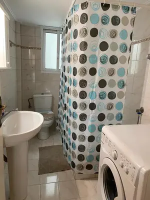 a bathroom with a washing machine and a sink at Kalamaki Apartments in Athens