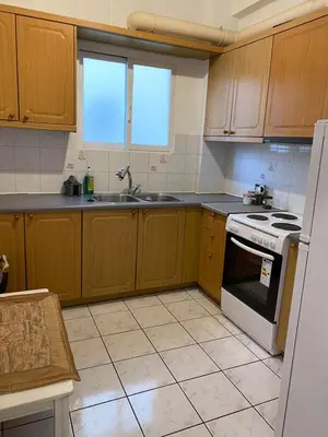 a kitchen with wooden cabinets and a white stove top oven at Kalamaki Apartments in Athens