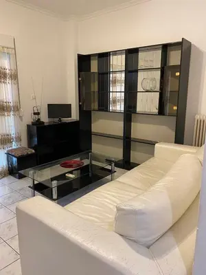 a living room with a white couch and a glass table at Kalamaki Apartments in Athens