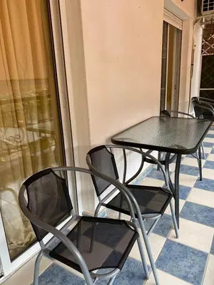 two black chairs and a table on a balcony at Kalamaki Apartments in Athens