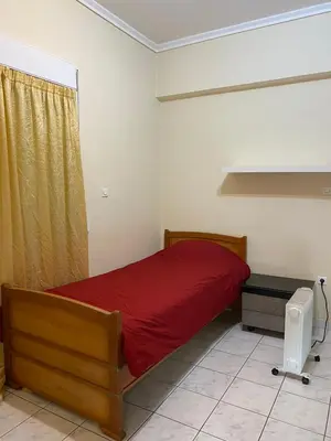 a bedroom with a red bed and a window at Kalamaki Apartments in Athens