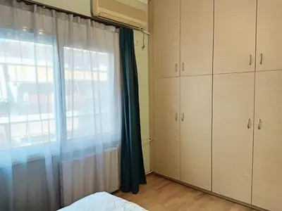 a bedroom with a bed and a window and cabinets at Bright 3bed 3bath 10 min walk Acropolis in Athens