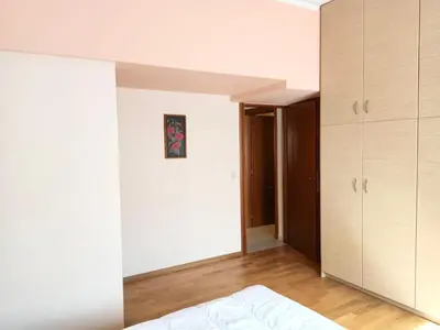 a bedroom with white walls and a bed and cabinets at Bright 3bed 3bath 10 min walk Acropolis in Athens