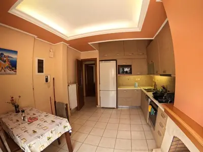 a kitchen with a table and a white refrigerator at Bright 3bed 3bath 10 min walk Acropolis in Athens