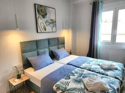 a bedroom with a bed with blue pillows and a window at Lux House Attiki VIPGreece in Athens