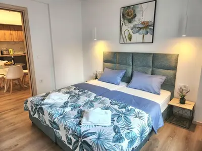 a bedroom with a large bed with blue pillows at Lux House Attiki VIPGreece in Athens