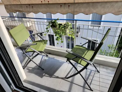 two green chairs sitting on a balcony at Lux House Attiki VIPGreece in Athens