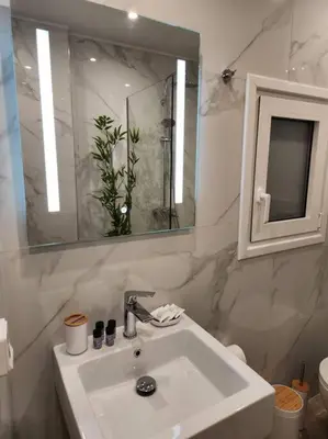 a white bathroom with a sink and a mirror at Lux House Attiki VIPGreece in Athens