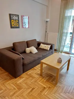 a living room with a brown couch and a coffee table at Christina-Anna Athens City Center walking distance to everywhere and Acropolis, in One of the most Favorable Locations by National Gardens and Zoo, Hellenic Parliament in Syntagma and Stylish Exquisite Kolonaki Cozy Renovated Apartment in Athens