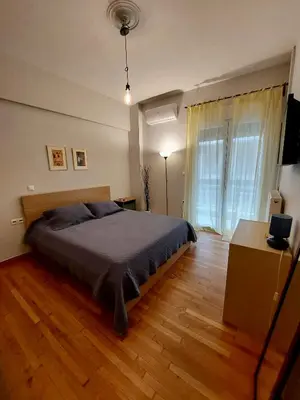 a bedroom with a bed and a wooden floor at Christina-Anna Athens City Center walking distance to everywhere and Acropolis, in One of the most Favorable Locations by National Gardens and Zoo, Hellenic Parliament in Syntagma and Stylish Exquisite Kolonaki Cozy Renovated Apartment in Athens